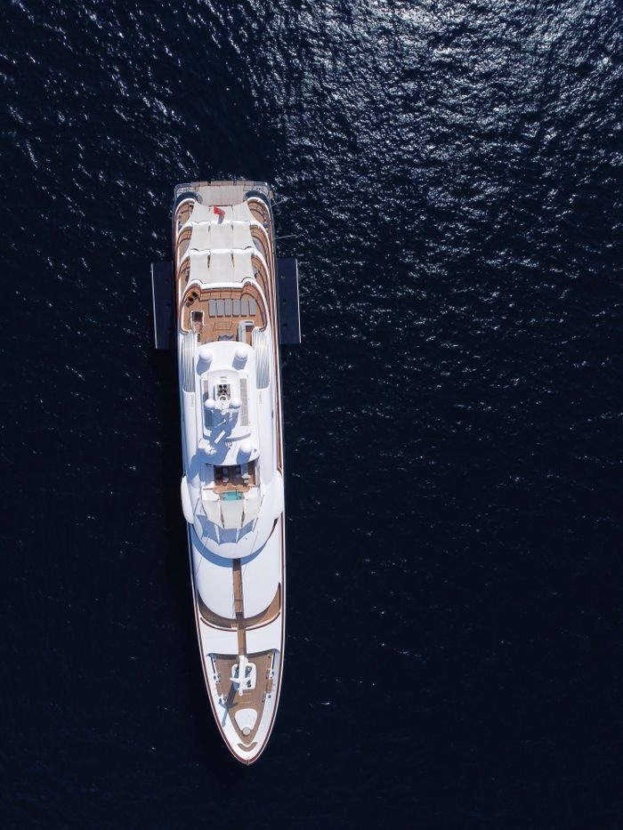 Stunning aerial shot of a luxury yacht navigating the blue waters near Olbia, Sardinia.