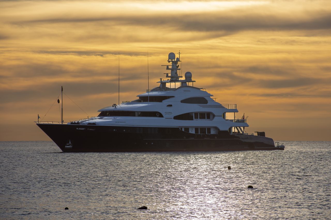 services-03 Stunning view of a luxury yacht sailing at sunset in Cabo San Lucas, Mexico's tranquil waters.