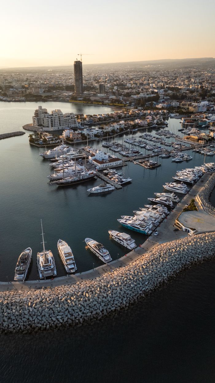 services-03 Stunning aerial shot of Limassol Marina with yachts and cityscape during golden sunset light.