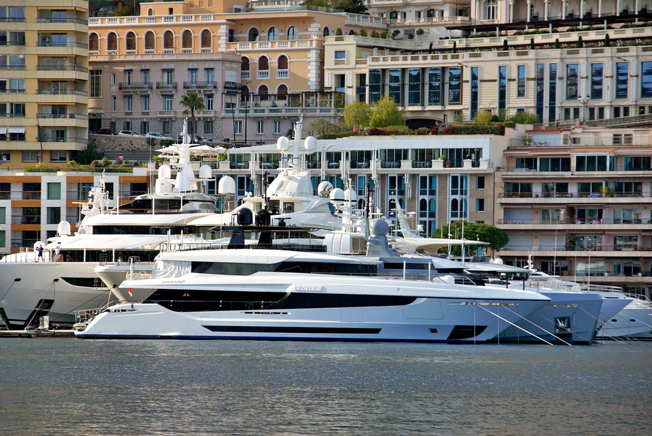 services-01 Stunning view of luxury yachts docked at Monaco harbor with elegant architecture in the background.