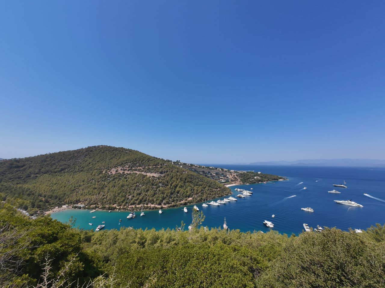 why-choose-us Stunning aerial photo of a serene coastal bay with yachts against a clear blue sky, perfect for travel and tourism themes.