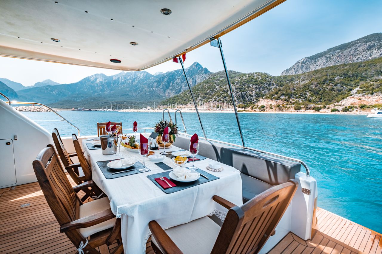 services-02 Elegant dining setup on a yacht overlooking Antalya's scenic coast in Türkiye.